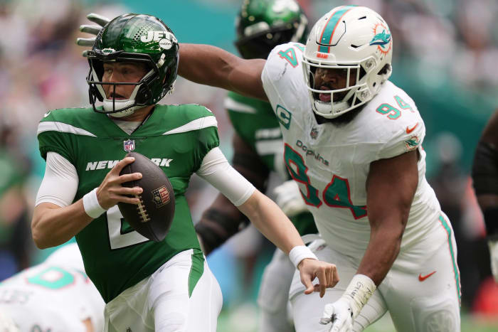 New York Jets linebacker Zach Wilson tries to escape pressure from Miami Dolphins defensive tackle Christian Wilkins during the first half at Hard Rock Stadium in Miami Gardens on Dec. 17, 2023.