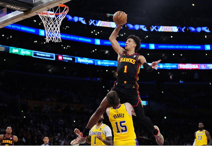 March 18, 2024;  Los Angeles, California, USA;  Atlanta Hawks forward Jalen Johnson (1) dunks the ball over Los Angeles Lakers guard Austin Reaves (15) in the first half at Crypto.com Arena.  Mandatory Credit: Kirby Lee-USA TODAY Sports
