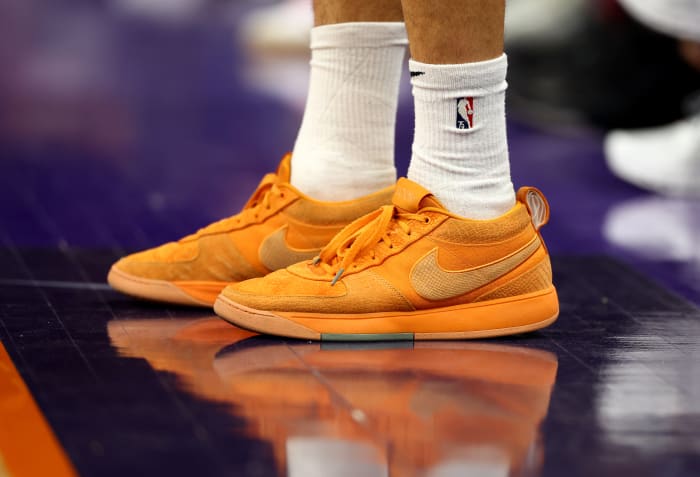 Phoenix Suns guard Devin Booker's orange Nike sneakers.