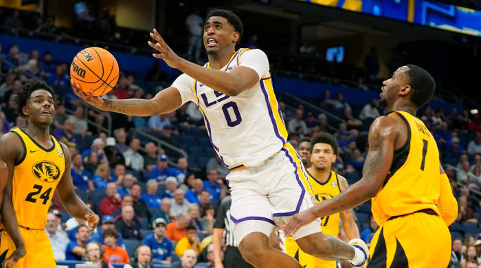 LSU guard Brandon Murray (0) goes to the basket to shoot past Missouri forward Kobe Brown (24) and guard Amari Davis, right, during the first half of an NCAA college basketball game at the Southeastern Conference tournament in Tampa, Fla., Thursday, March 10, 2022.