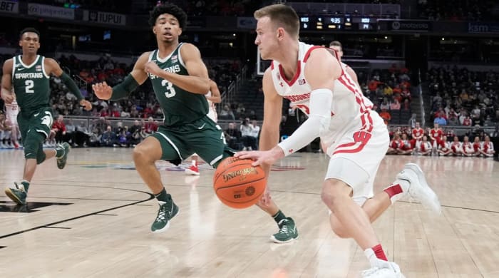 Wisconsin’s Brad Davison, right, goes to the basket against Michigan State’s Jaden Akins (3) during the first half of an NCAA college basketball game at the Big Ten Conference tournament, Friday, March 11, 2022, in Indianapolis.
