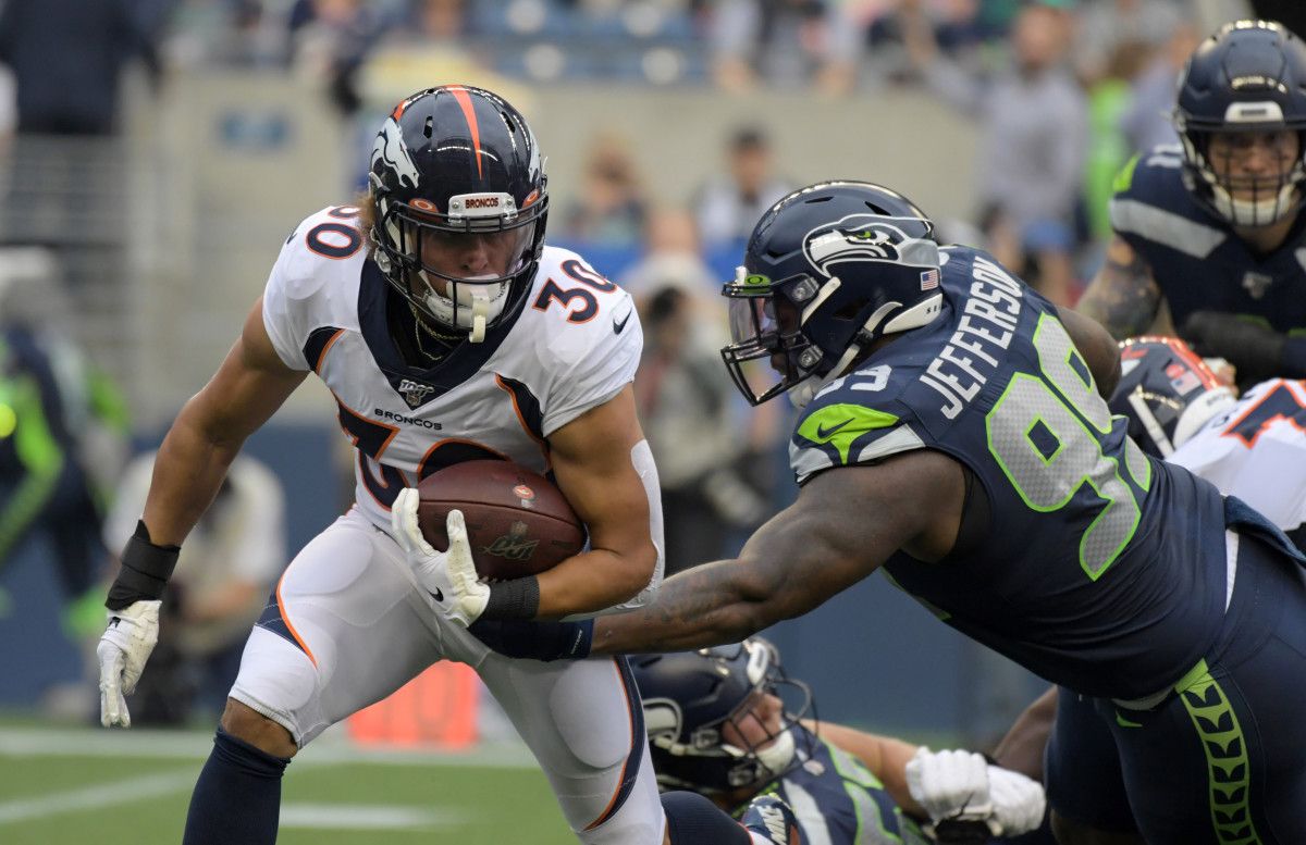 Denver Broncos running back Phillip Lindsay (30) runs the ball against Seattle Seahawks defensive tackle Quinton Jefferson (99) in the first quarter at CenturyLink Field.