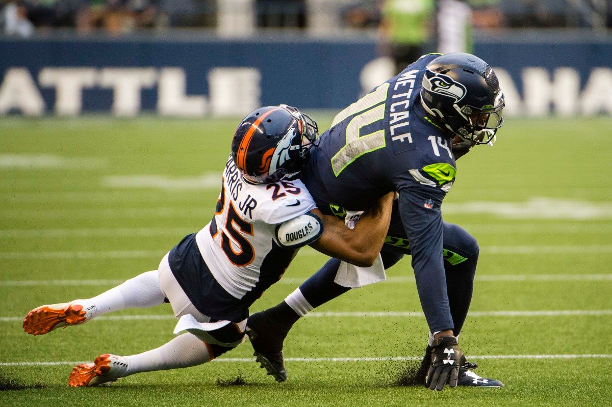 Denver Broncos cornerback Chris Harris (25) tackles Seattle Seahawks wide receiver D.K. Metcalf (14) during the first half at CenturyLink Field.