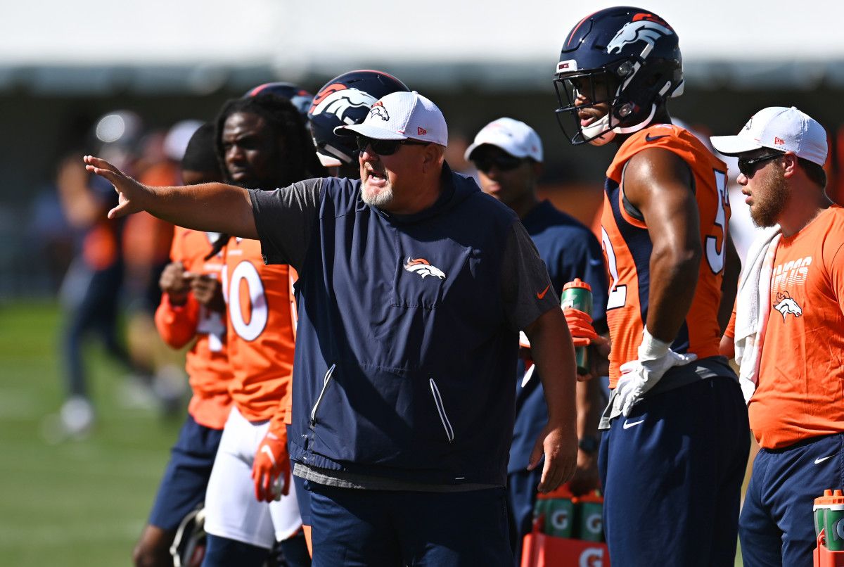 Denver Broncos linebacker Justin Hollins (52) and linebackers coach Reggie Herring during drills at the UCHealth Training Center.