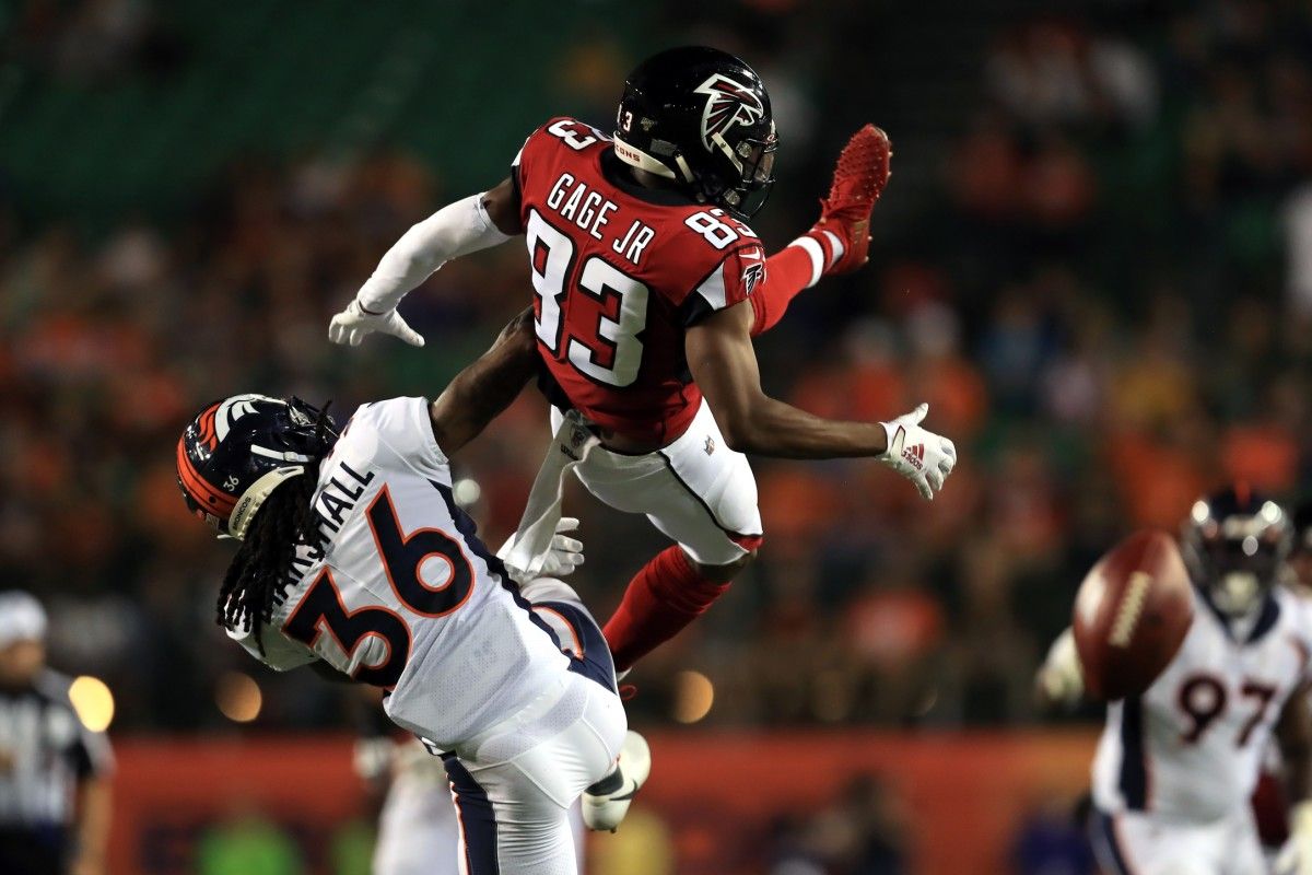 Denver Broncos defensive back Trey Marshall (36) breaks up a pass as he upends Atlanta Falcons wide receiver Russell Gage (83) in the first half at Tom Benson Hall of Fame Stadium.