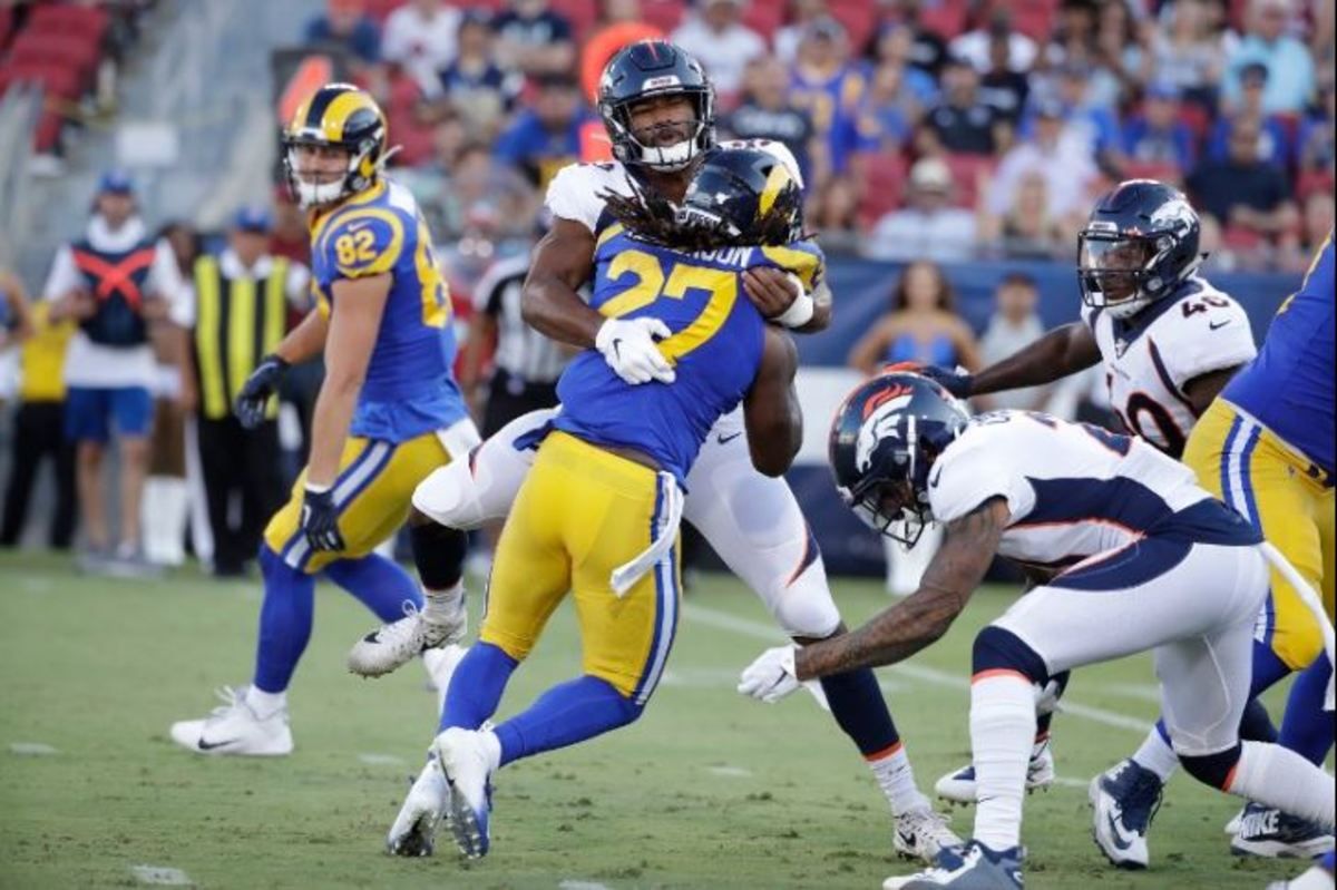 Los Angeles Rams running back Darrell Henderson (27) is tackled by Denver Broncos linebacker Justin Hollins during the first half of an NFL preseason football game Saturday, Aug. 24, 2019, in Los Angeles.