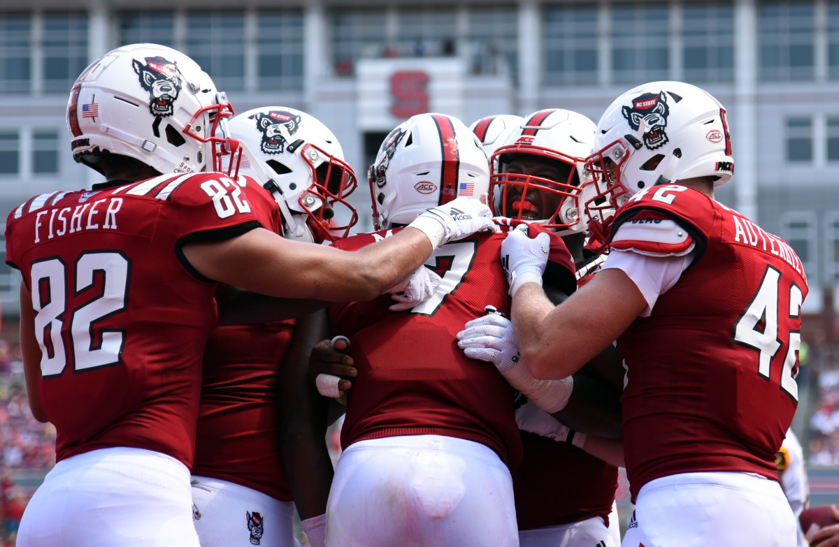 Members of the Wolfpack congratulate quarterback Matthew McKay after his second quarter touchdown Saturday