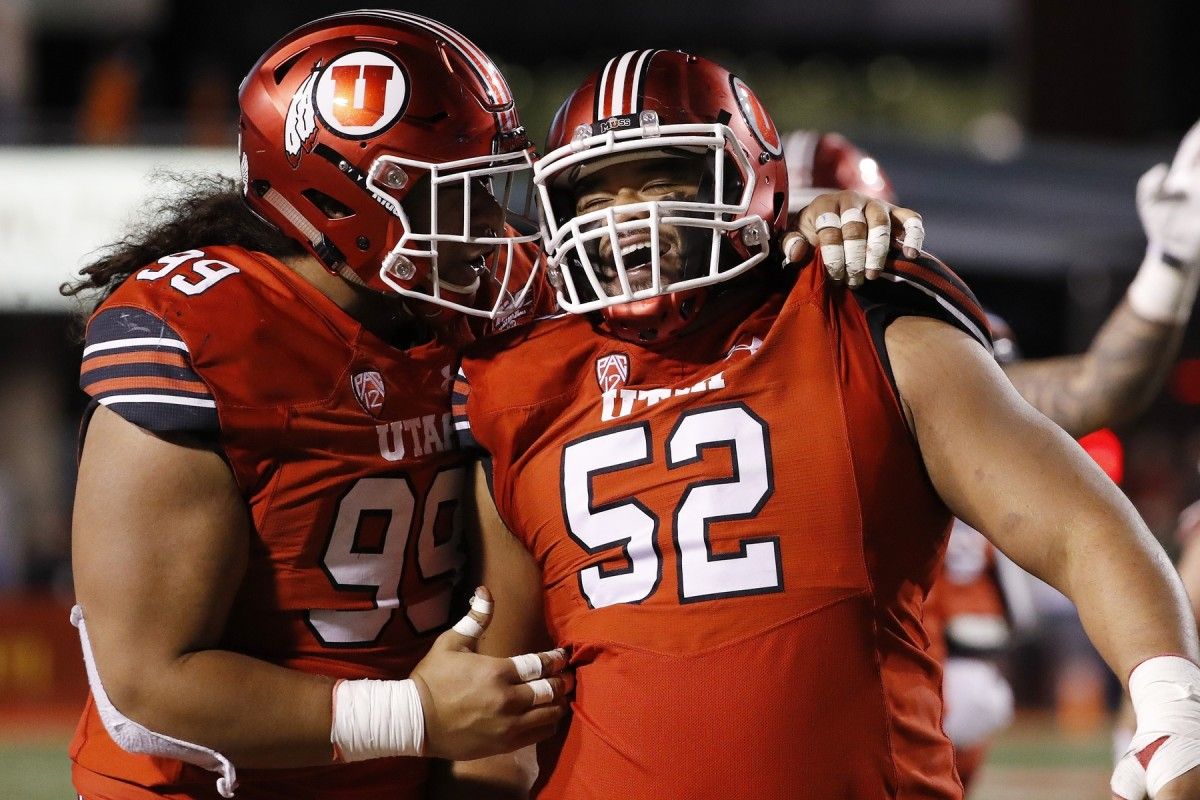 Utah Utes defensive tackle Leki Fotu (99) and defensive tackle John Penisini (52) celebrate after a stop in the fourth quarter against the Brigham Young Cougars at Rice-Eccles Stadium.