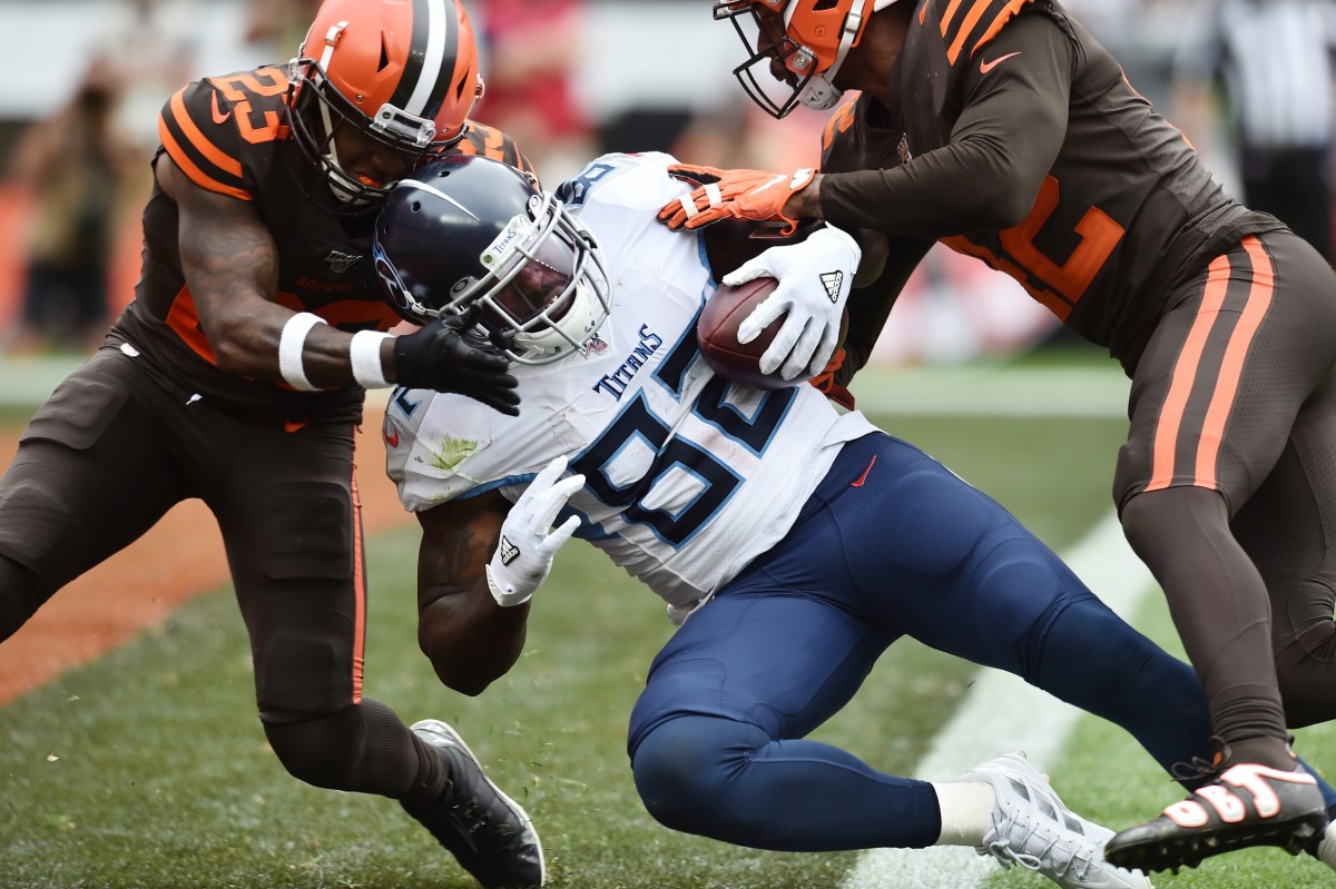 Tennessee Titans tight end Delanie Walker (82) scores a touchdown as Cleveland Browns strong safety Damarious Randall (23) and strong safety Morgan Burnett (42) defend during the second half at FirstEnergy Stadium.