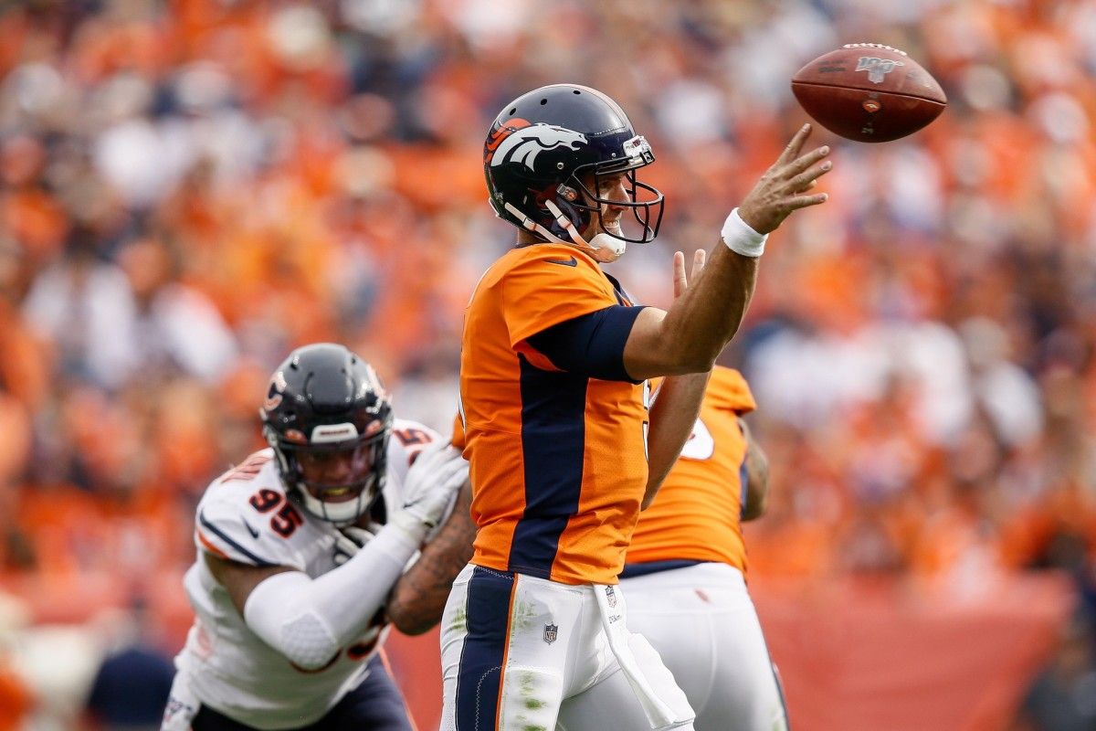 Denver Broncos quarterback Joe Flacco (5) attempts a pass as offensive tackle Dalton Risner (66) defends against Chicago Bears defensive end Roy Robertson-Harris (95) in the third quarter at Empower Field at Mile High.