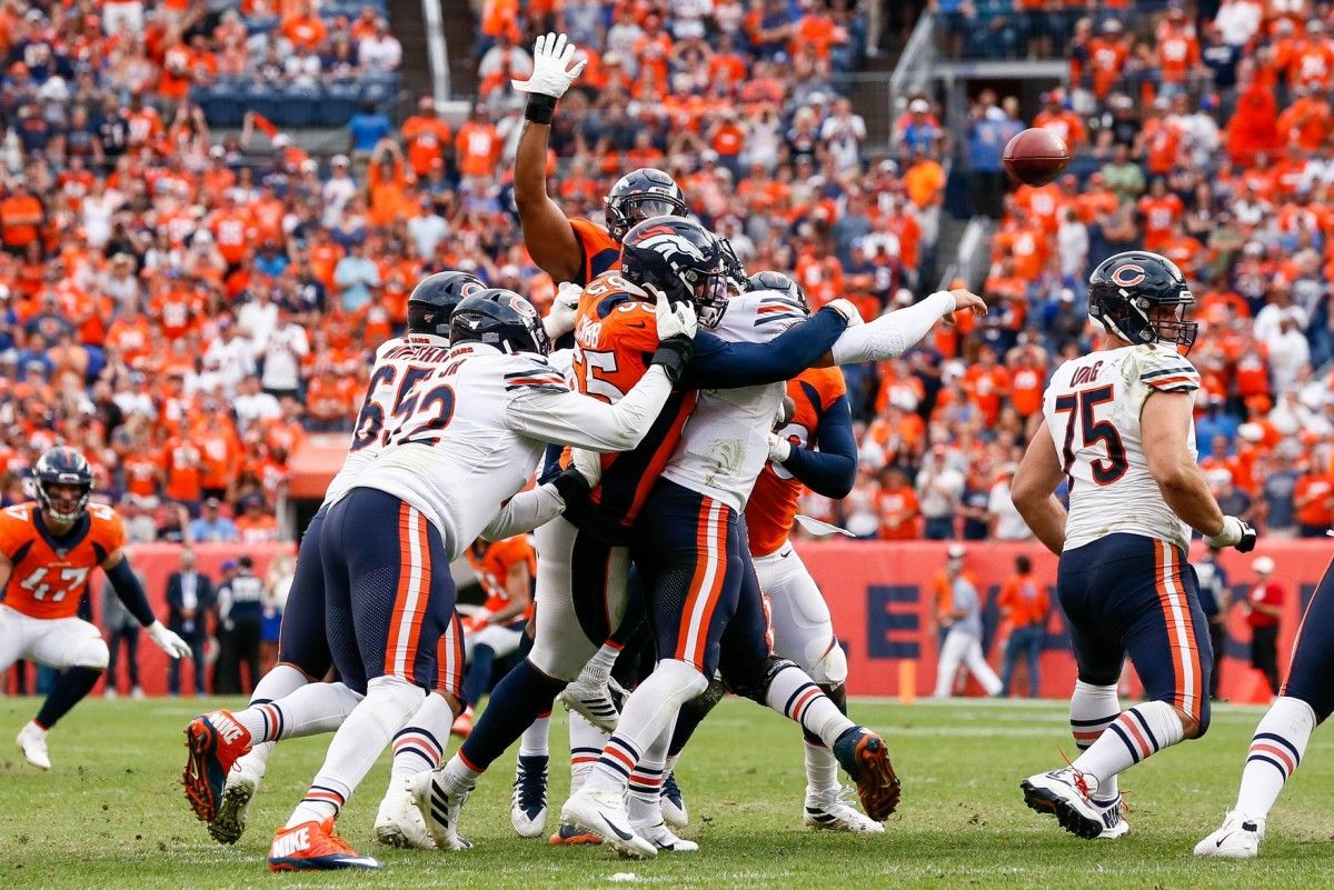 Chicago Bears quarterback Mitchell Trubisky (10) attempts a pass under pressure from Denver Broncos linebacker Bradley Chubb (55) as offensive tackle Charles Leno Jr. (72) defends in the fourth quarter at Empower Field at Mile High.