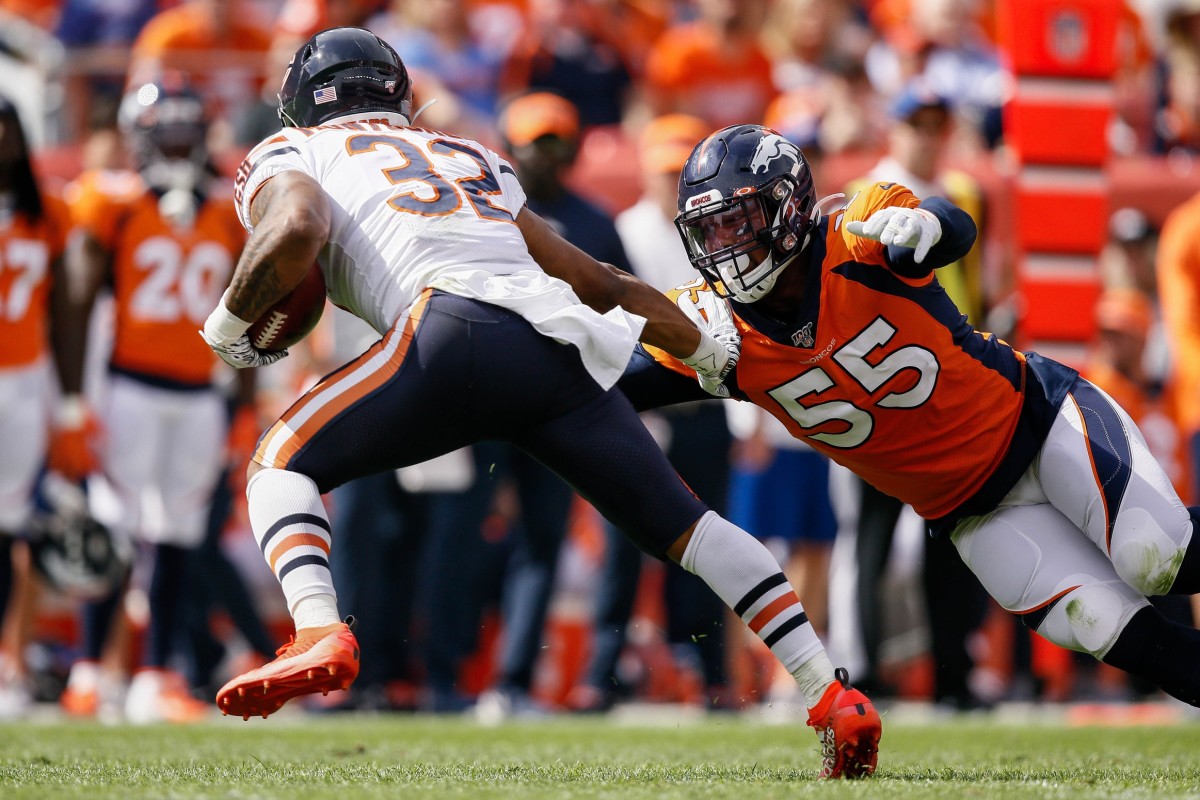 Chicago Bears running back David Montgomery (32) sides steps the tackle of Denver Broncos linebacker Bradley Chubb (55) in the first quarter at Empower Field at Mile High.