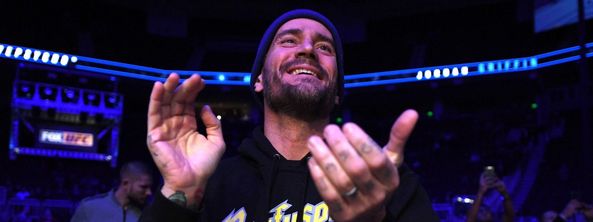 CM Punk claps at a UFC event