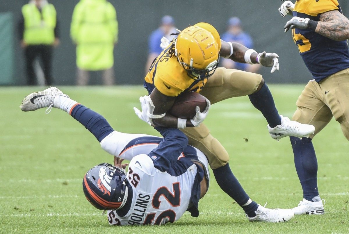 Green Bay Packers running back Jamaal Williams (30) is tackled by Denver Broncos linebacker Justin Hollins (52) in the third quarter at Lambeau Field.