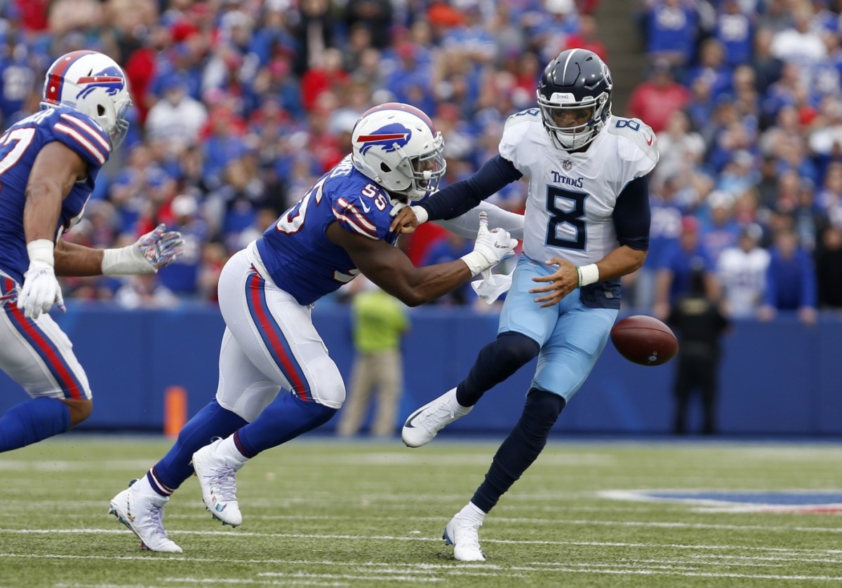Buffalo Bills defensive end Jerry Hughes (55) forces a fumble against Tennessee Titans quarterback Marcus Mariota (8) during the second half at New Era Field.
