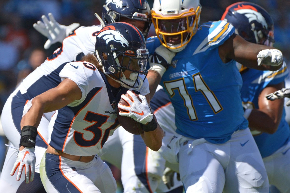 Denver Broncos running back Phillip Lindsay (30) runs the ball as Los Angeles Chargers defensive end Damion Square (71) defends during the first quarter at Dignity Health Sports Park.