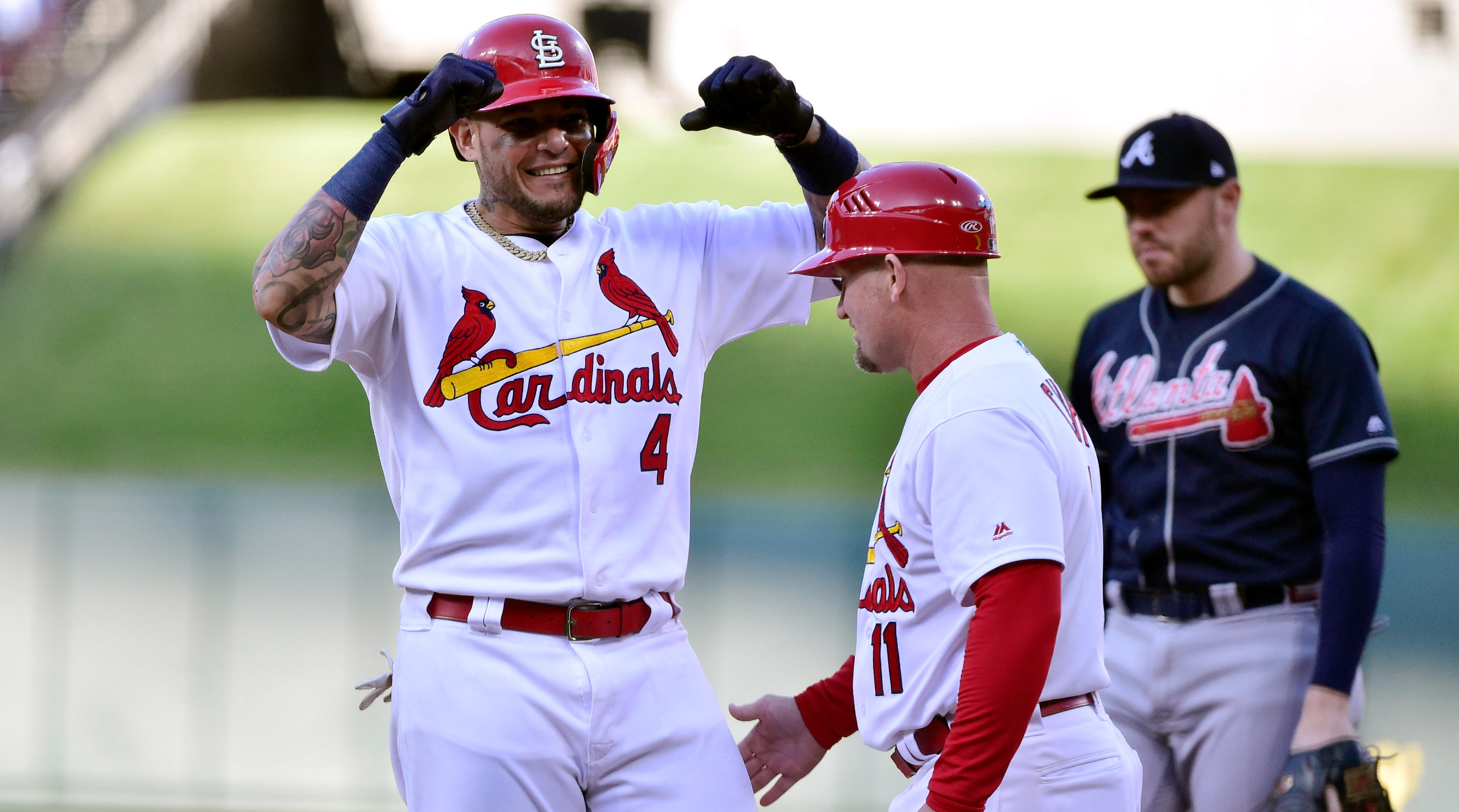 Oct 7, 2019; St. Louis, MO, USA; St. Louis Cardinals catcher Yadier Molina (4) celebrates with first base coach Stubby Clapp (11) after hitting an RBI single in the eighth inning against the Atlanta Braves in game four of the 2019 NLDS playoff baseball series at Busch Stadium. Mandatory Credit: Jeff Curry-USA TODAY Sports