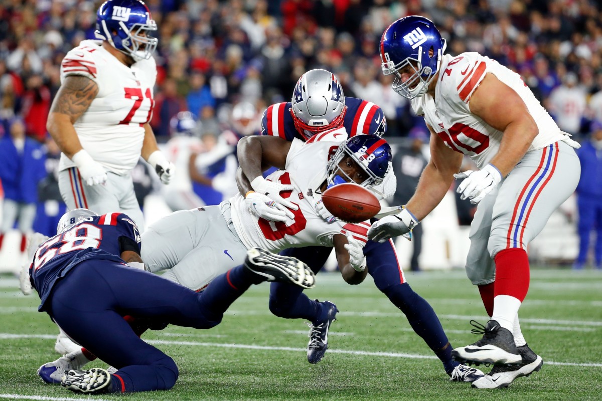 Oct 10, 2019; Foxborough, MA, USA; New York Giants running back Jon Hilliman (28) fumbles the ball after a hit by New England Patriots outside linebacker Jamie Collins (58) during the second half at Gillette Stadium.