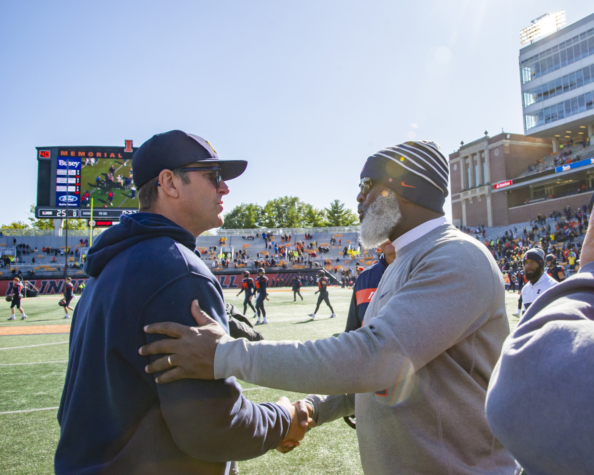Michigan Wolverines head coach Jim Harbaugh and Illinois Fighting Illini head coach Lovie Smith meet after a game at Memorial Stadium.
