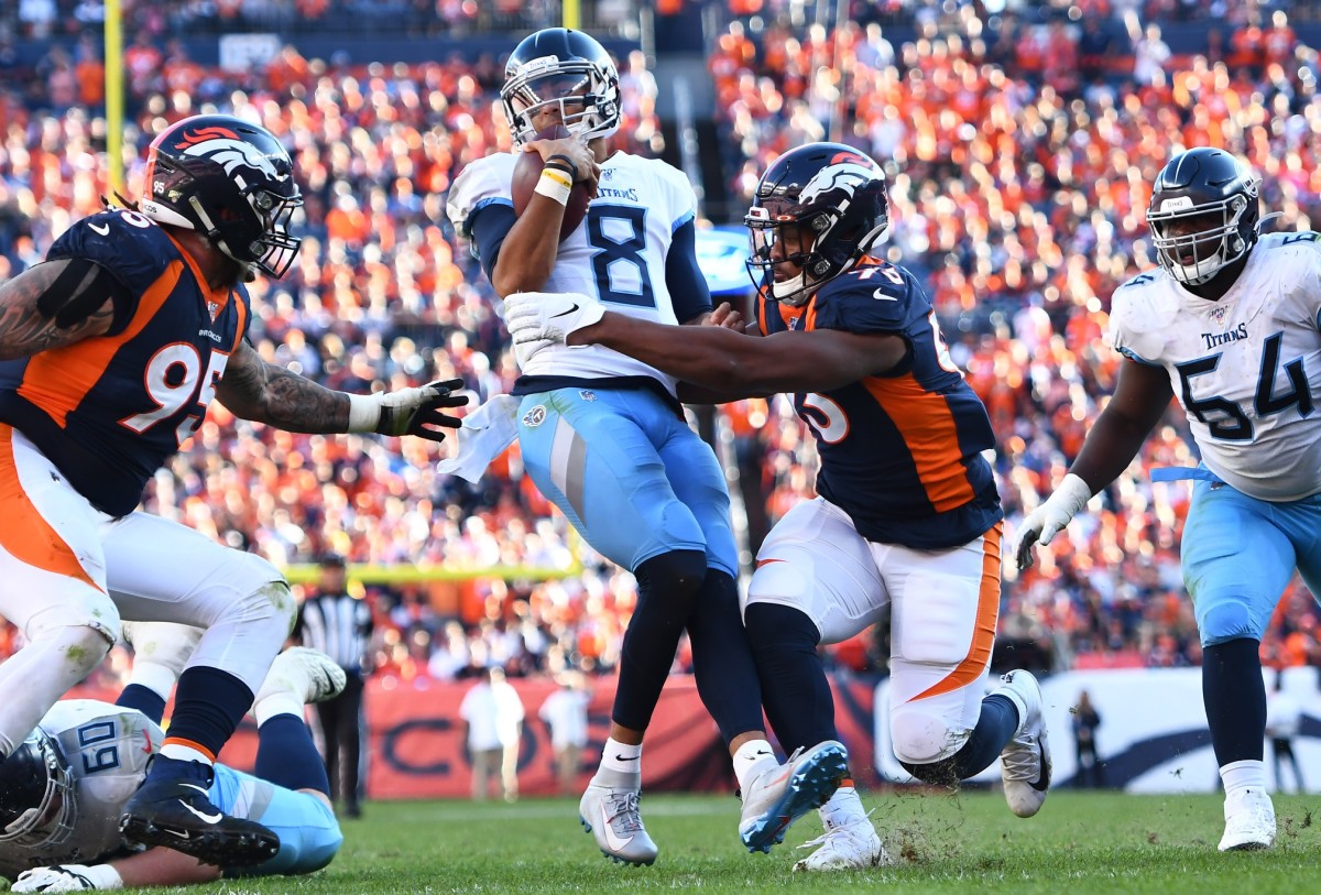 Denver Broncos defensive end Dre'Mont Jones (93) attempts to tackle Tennessee Titans quarterback Marcus Mariota (8) in the third quarter at Empower Field at Mile High.