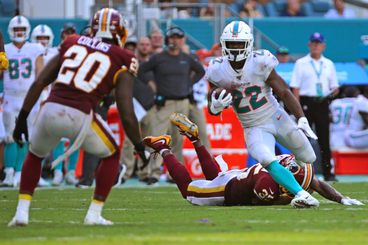 Oct 13, 2019; Miami Gardens, FL, USA; Miami Dolphins running back Mark Walton (22) carries the ball and avoids a tackle by Washington Redskins strong safety Montae Nicholson (35) in the fourth quarter of the game at Hard Rock Stadium. Mandatory Credit: Sam Navarro-USA TODAY Sports