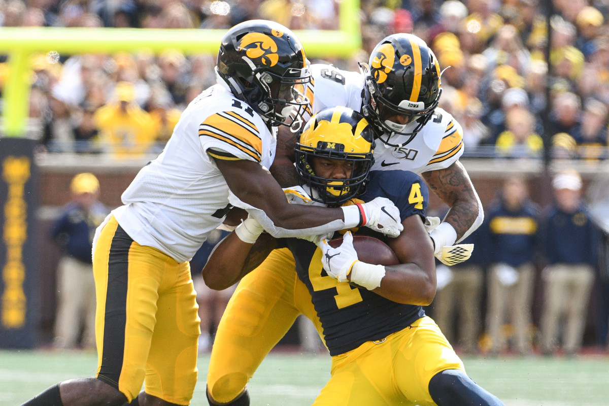 Michigan wide receiver Nico Collins (4) is tackled by Iowa cornerback Michael Ojemudia (11) and defensive back Geno Stone in the Oct. 5 game at Ann Arbor, Mich.