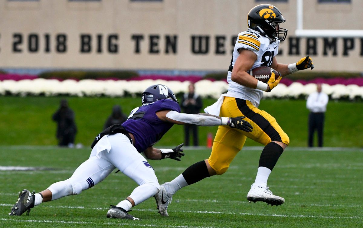 Iowa tight end Sam LaPorta gets away from Northwestern's Greg Newsome II in Saturday's game.