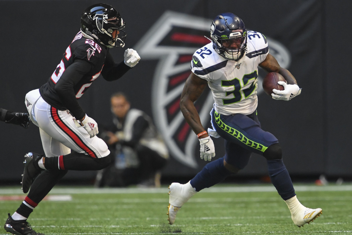 Seattle Seahawks running back Chris Carson (32) runs against Atlanta Falcons cornerback Isaiah Oliver (26) during the first quarter at Mercedes-Benz Stadium. Mandatory Credit: Dale Zanine-USA TODAY Sports