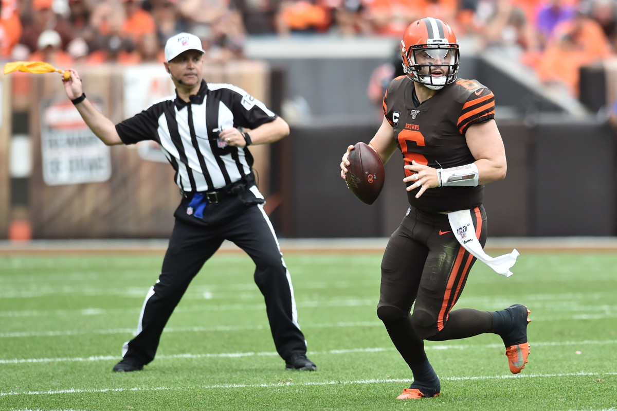 Sep 8, 2019; Cleveland, OH, USA; Cleveland Browns quarterback Baker Mayfield (6) scrambles as field judge Michael Banks (72) throws a penalty flag during the second half against the Tennessee Titans at FirstEnergy Stadium. Mandatory Credit: Ken Blaze-USA TODAY Sports