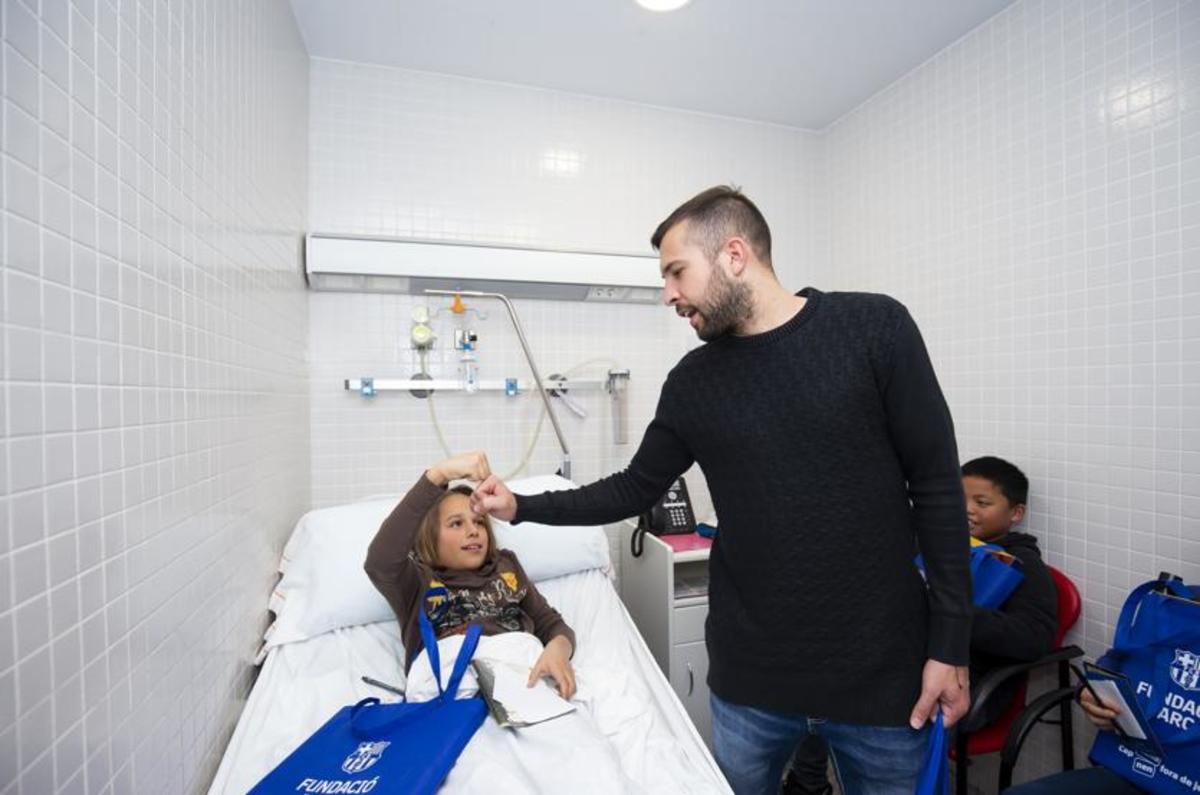 Jordi Alba saluda a una niÃ±a en la visita al Hospital de Nens de Barcelona.