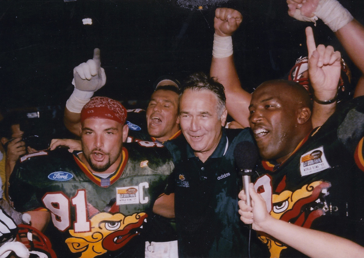 Naposki celebrates with Barcelona Dragons coach Jack Bicknell (center) and other teammates after their 1997 World Bowl victory.