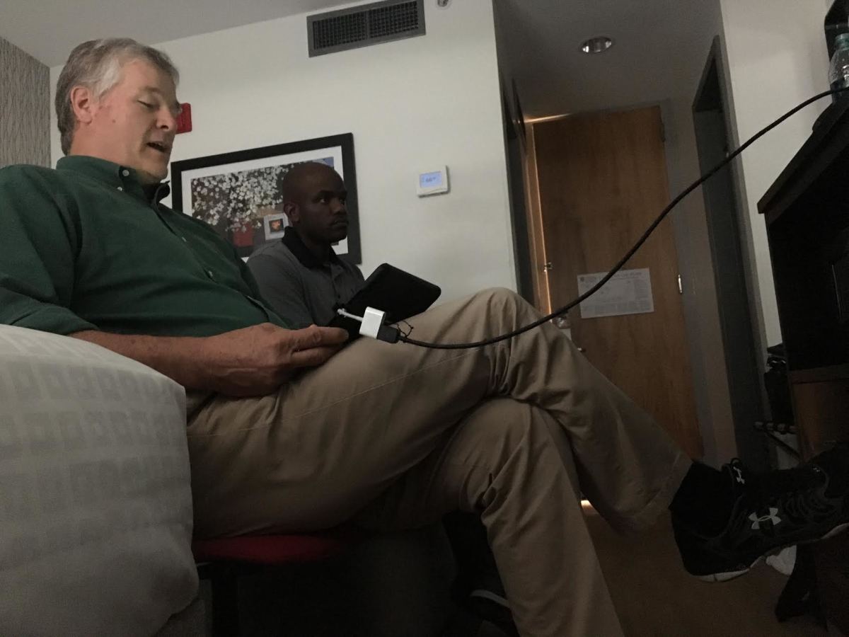 Russ Pulley, an 18-year veteran of SEC officiating, reviews plays on an iPad connected to a TV from a room at the University of Georgia Hotel.