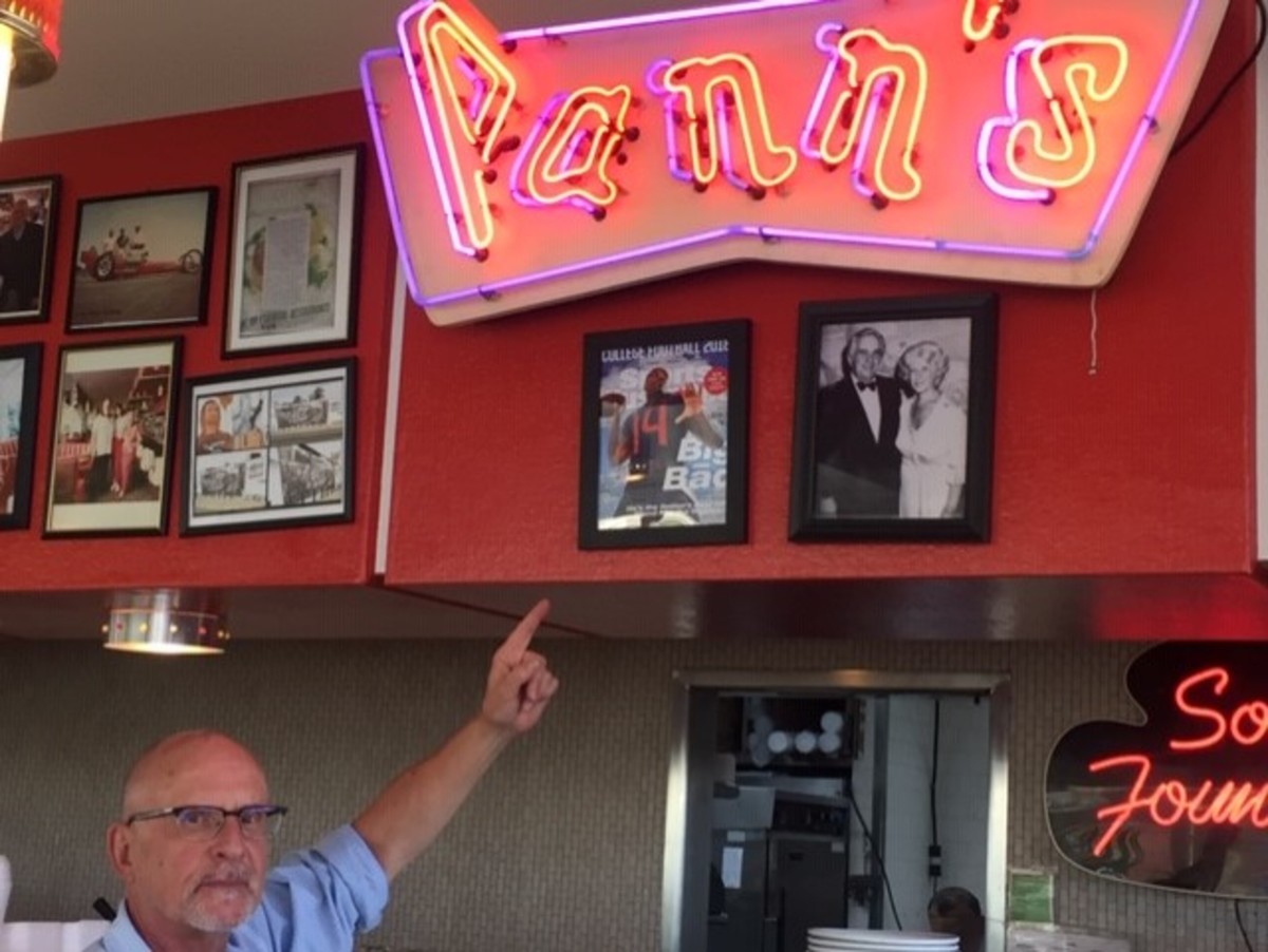 Jim Poulos, the owner of Pann's Restaurant in Los Angeles, points at the August 2018 Sports Illustrated regional cover picturing a neighborhood kid, LA-born Arizona quarterback Khalil Tate.