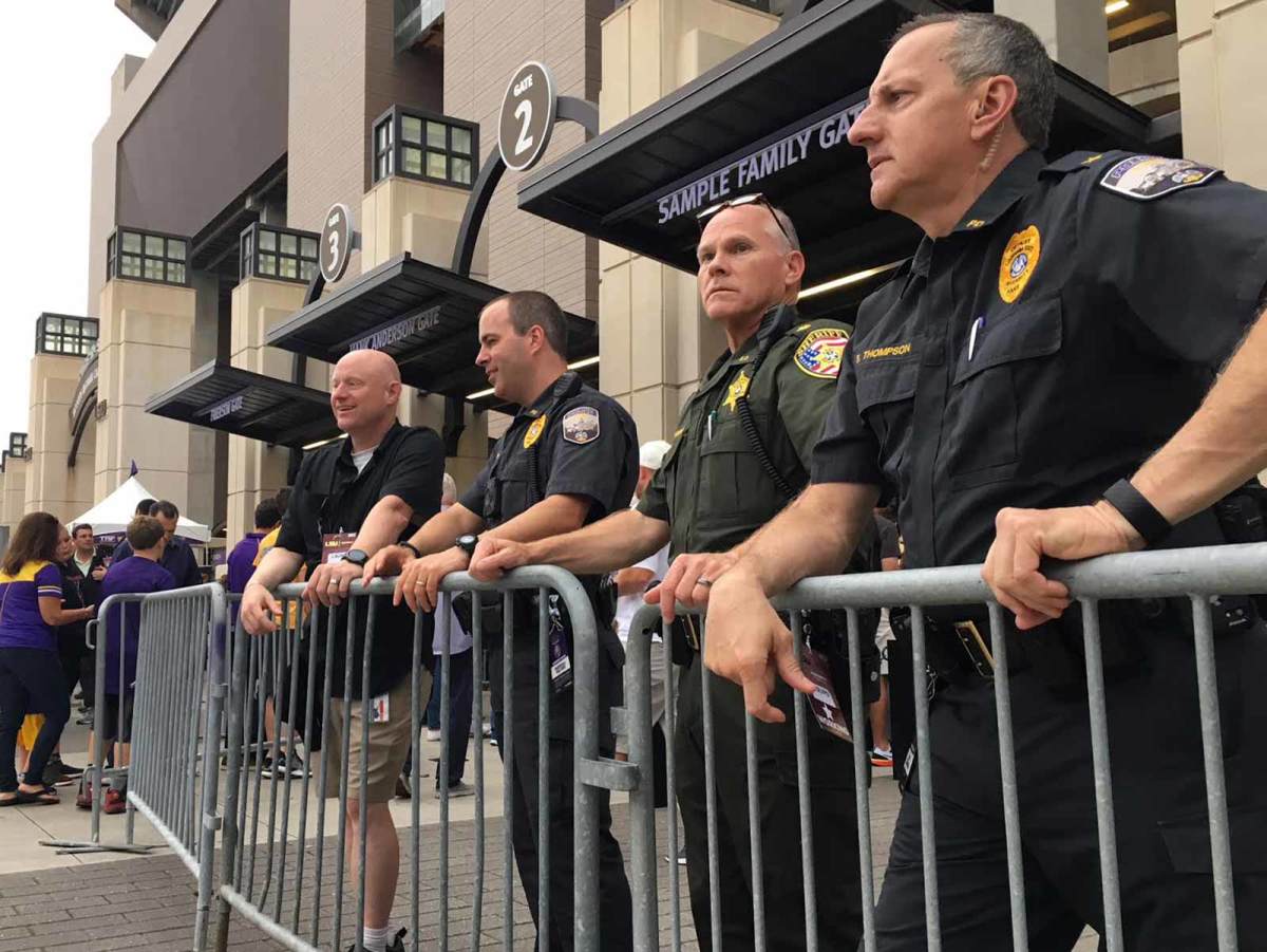Three of LSU's four game day law enforcement supervisors watch as fans file into Tiger Stadium through new metal detectors. LSU Police Chief Bart Thompson, far right, stands next to East Baton Rouge Parish Maj. Todd Morris and LSU Police Maj. Marshall Walters.