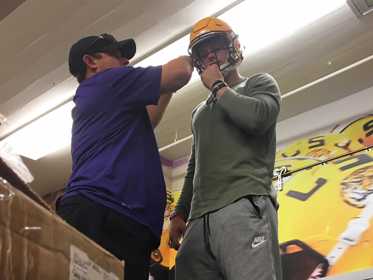 Equipment director Greg Stringfellow fits Ohio State transfer Joe Burrow with his new LSU helmet.