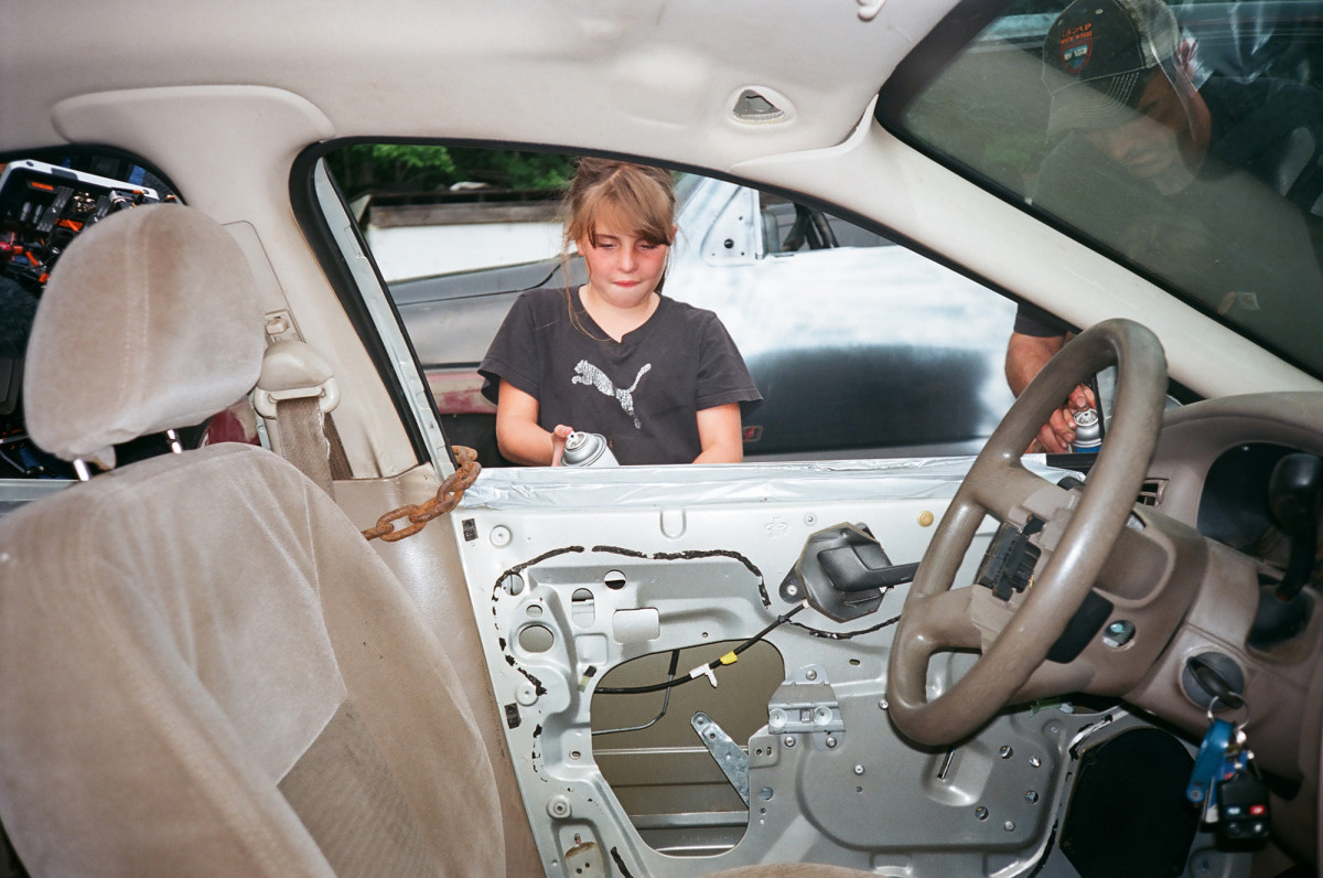 Madison Leavitt helps her father prepare the cars for the demolition derby.