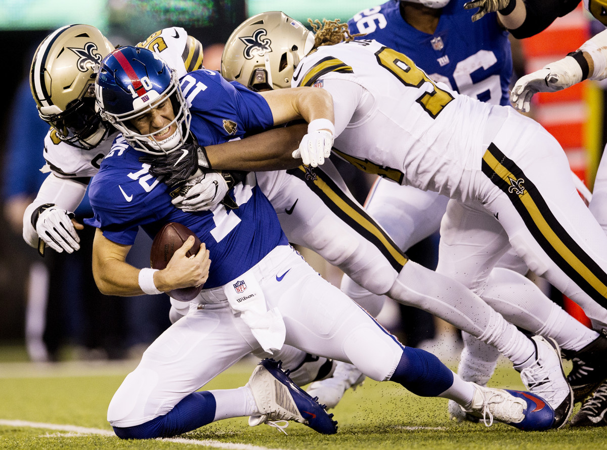 New York Giants QB Eli Manning against New Orleans Saints' Demario Davis and Cameron Jordan at MetLife Stadium