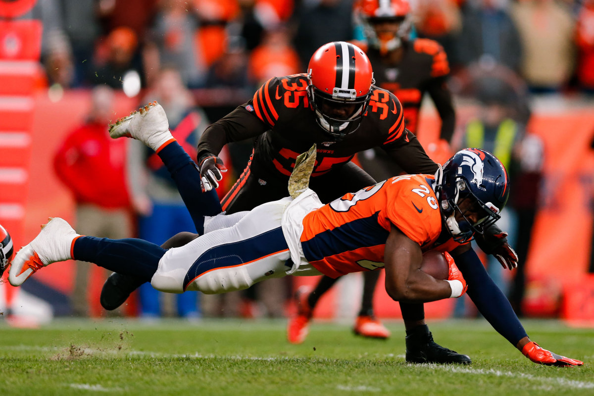 Nov 3, 2019; Denver, CO, USA; Denver Broncos running back Royce Freeman (28) is tripped up running the ball as Cleveland Browns safety Jermaine Whitehead (35) defends in the third quarter at Empower Field at Mile High. Mandatory Credit: Isaiah J. Downing-USA TODAY Sports