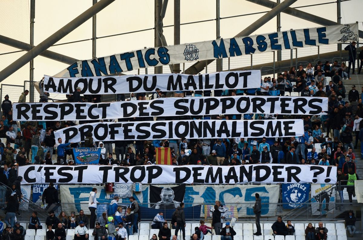 Olympique de Marseille (OM) fans hold a banner reading 'for the love of the OM jersey, the respect of fans and professionalism, is it too much to ask?', prior to the start of the French L1 football match between Olympique de Marseille (OM) and Caen at the Velodrome stadium