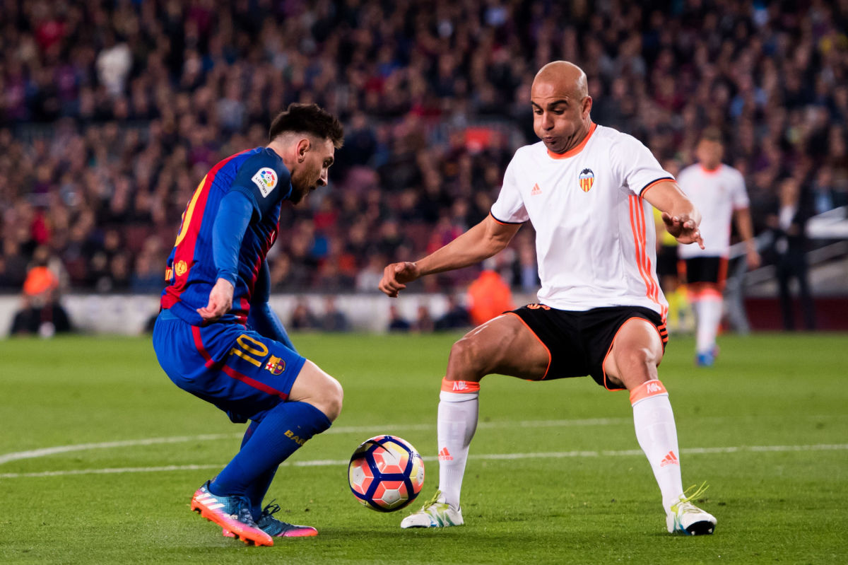 BARCELONA, SPAIN - MARCH 19:  Lionel Messi (L) of FC Barcelona dribbles Aymen Abdennour of Valencia CF before scoring his team's third goal during the La Liga match between FC Barcelona and Valencia CF at Camp Nou stadium on March 19, 2017 in Barcelona, Spain.  (Photo by Alex Caparros/Getty Images)