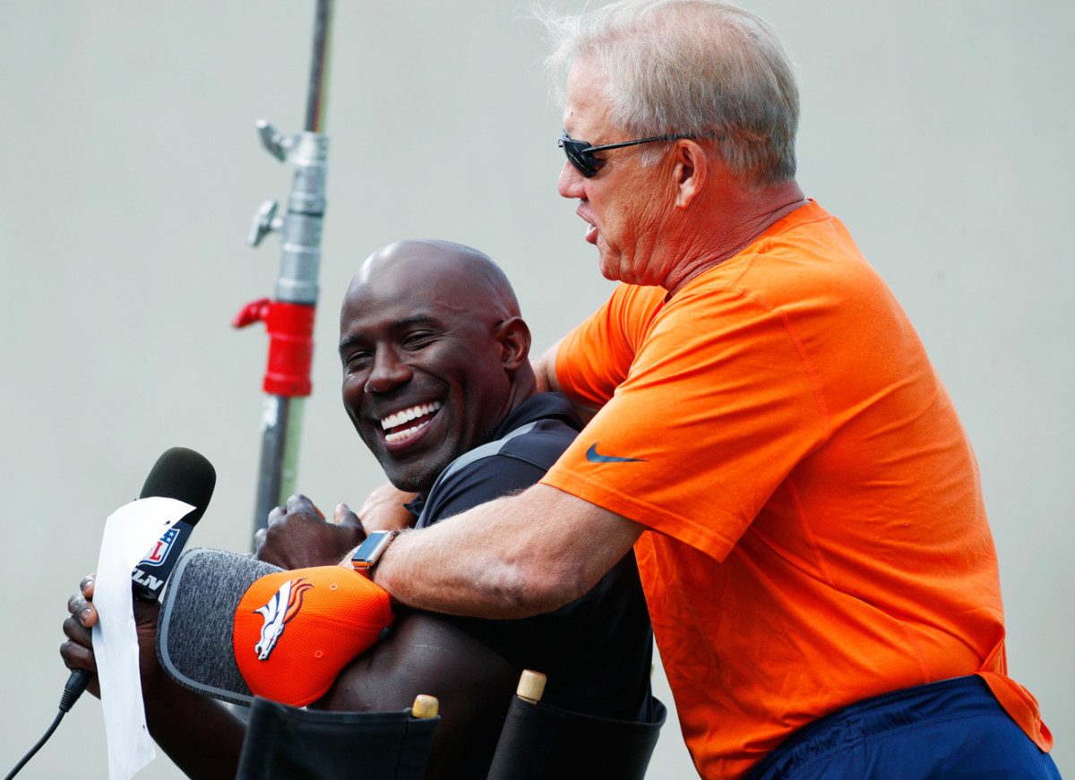 John Elway messes around with former teammate and current NFL Network analyst Terrell Davis during Broncos camp on Sunday.