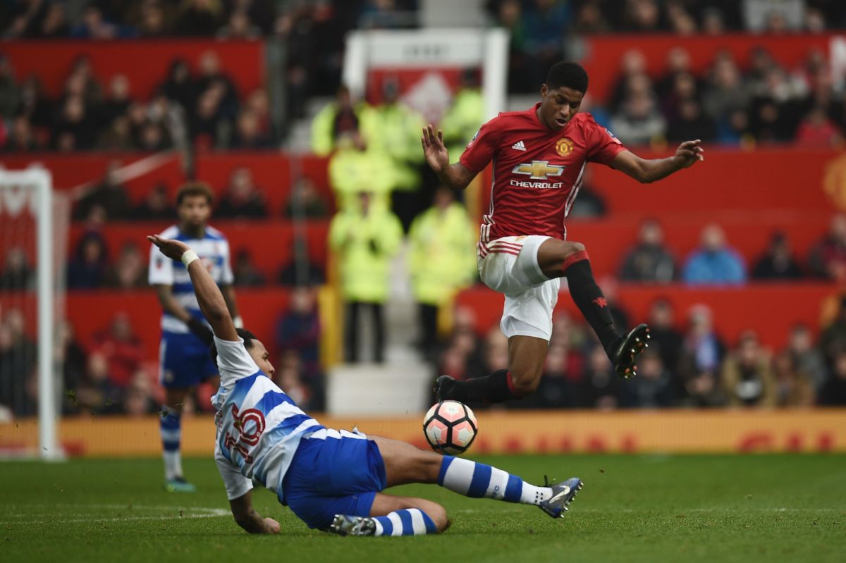 Manchester United's English striker Marcus Rashford (R) leaps a challenge from Reading's English defender Liam Moore (L) during the English FA Cup third round football match between Manchester United and Reading at Old Trafford in Manchester, north west England, on January 7, 2017. / AFP / Oli SCARFF / RESTRICTED TO EDITORIAL USE. No use with unauthorized audio, video, data, fixture lists, club/league logos or 'live' services. Online in-match use limited to 75 images, no video emulation. No use in betting, games or single club/league/player publications.  /         (Photo credit should read OLI SCARFF/AFP/Getty Images)