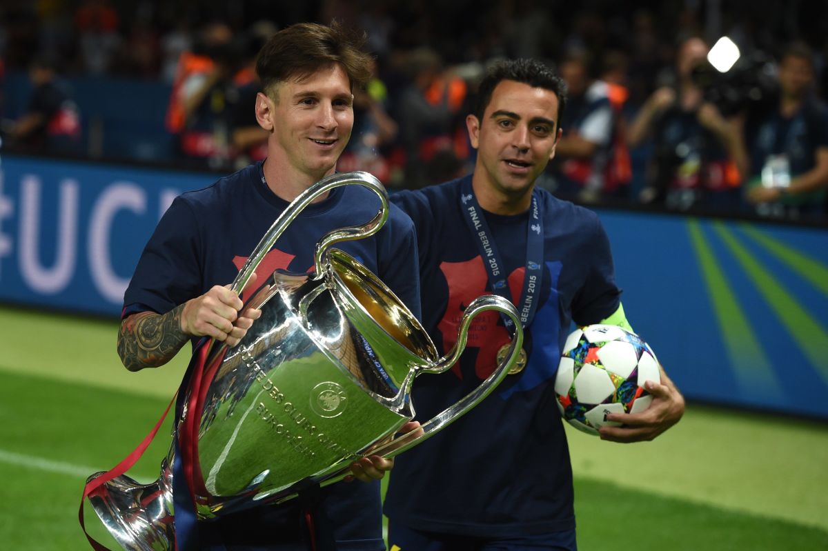Barcelona's midfielder Xavi Hernandez (R) and Barcelona's Argentinian forward Lionel Messi celebrate with the trophy after the UEFA Champions League Final football match between Juventus and FC Barcelona at the Olympic Stadium in Berlin on June 6, 2015. FC Barcelona won the match 1-3.        AFP PHOTO / PATRIK STOLLARZ        (Photo credit should read PATRIK STOLLARZ/AFP/Getty Images)