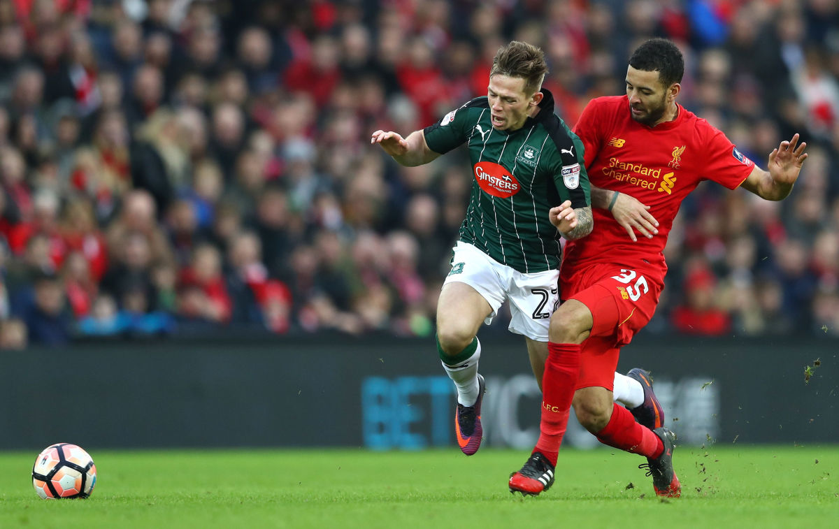 LIVERPOOL, ENGLAND - JANUARY 08: Craig Tanner of Plymouth Argyle (L) is fouled by Kevin Stewart of Liverpool (R) during The Emirates FA Cup Third Round match between Liverpool and Plymouth Argyle at Anfield on January 8, 2017 in Liverpool, England.  (Photo by Michael Steele/Getty Images)