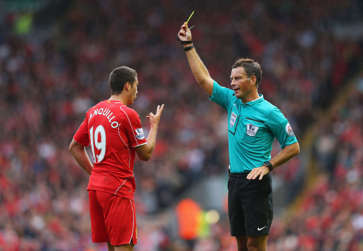 LIVERPOOL, ENGLAND - AUGUST 17: Referee Mark Clattenburg shows the yellow card to Javi Manquillo of Liverpool during the Barclays Premier League match between Liverpool and Southampton at Anfield on August 17, 2014 in Liverpool, England.  (Photo by Alex Livesey/Getty Images)