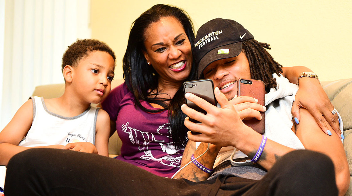 Sidney Jones keeping a close eye on his two phones with his mother and his brother.