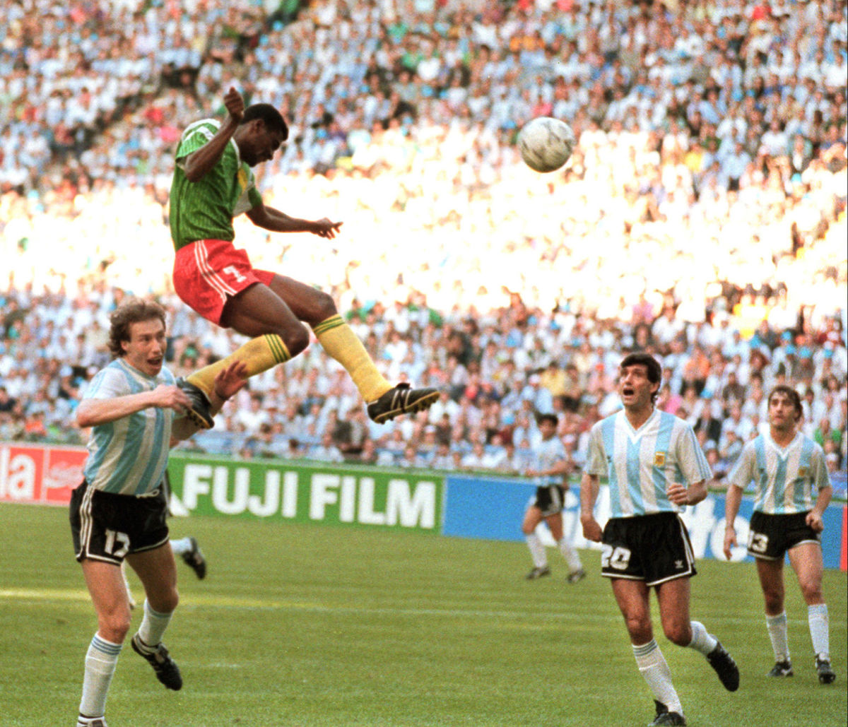 Forward Francois Omam-Biyick from Cameroon scores on a header as Argentinian defenders Nestor Lorenzo (L) and Juan Simon look on 08 June 1990 in Milan during the World Cup opening match between Cameroon and Argentina. Despite two expulsions, Cameroon upset the defending World champions 1-0. AFP PHOTO (Photo credit should read STAFF/AFP/Getty Images)