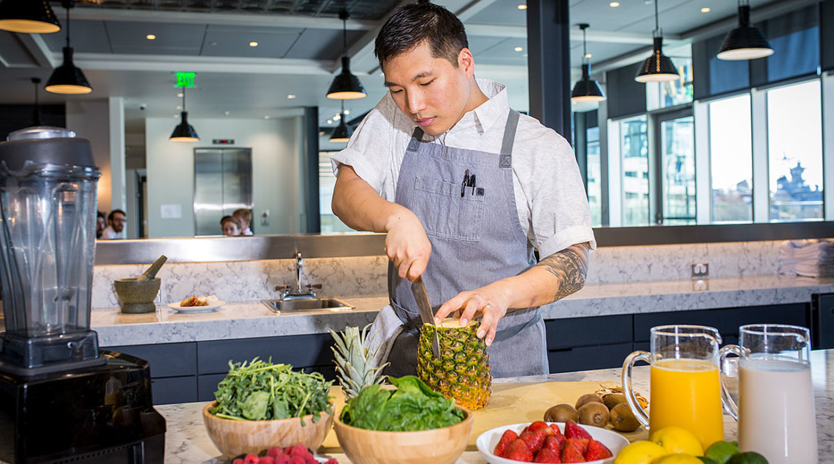 76ers executive chef JaeHee Cho slices a pineapple. 