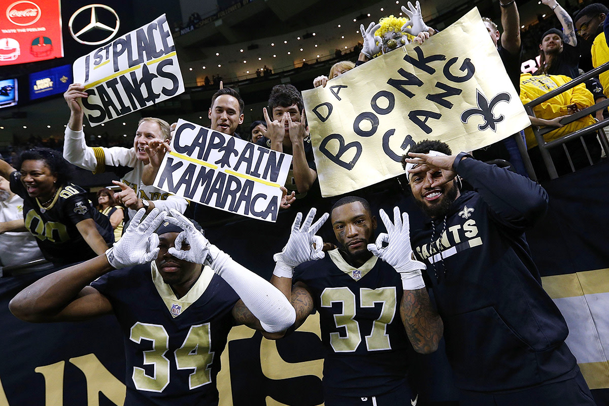 Marshon Lattimore (right, in street clothes) celebrates a Saints win against the Panthers.