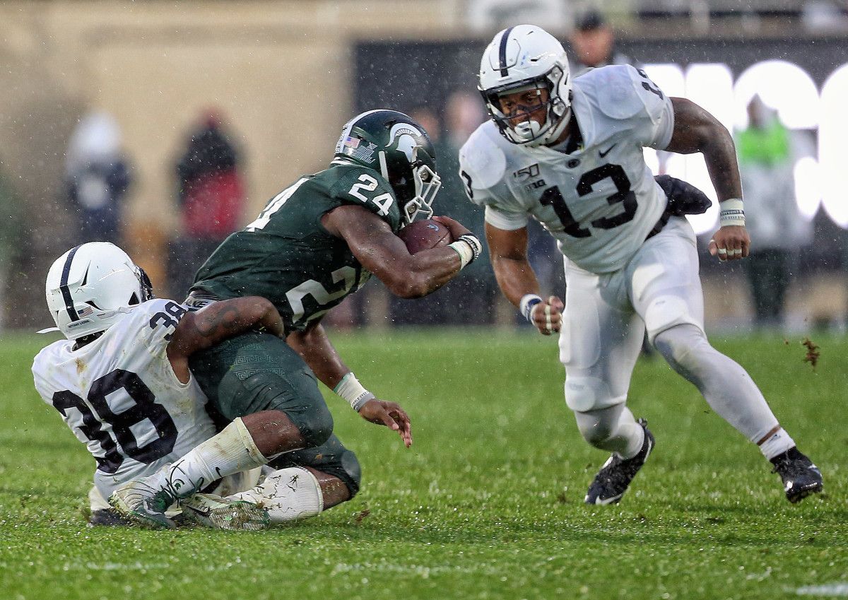 Michigan State Spartans running back Elijah Collins (24) is tackled by Penn State Nittany Lions safety Lamont Wade (38) during the second half of a game at Spartan Stadium.